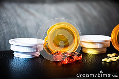 Dark Background with Open Pill bottles and Capsules Stock Photo