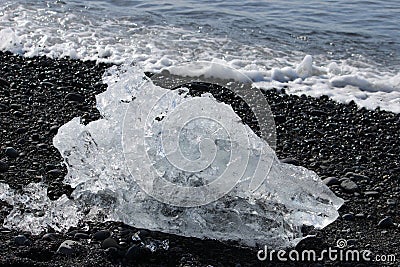 Big piece of ice on the rocky shore Stock Photo