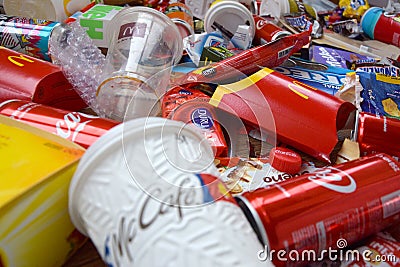 Big pile of many disposable colored trash from edible products of famous food and beverage manufacturers. Soda cans and chocolate Editorial Stock Photo