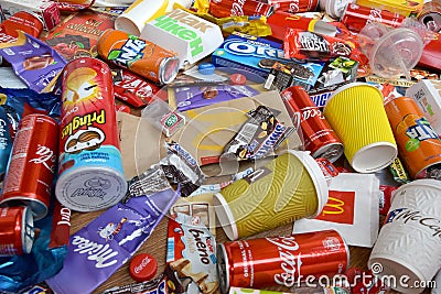 Big pile of many disposable colored trash from edible products of famous food and beverage manufacturers. Soda cans and chocolate Editorial Stock Photo