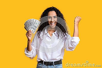 Big prize. Happy woman holding lots of money and shouting, orange background with free space Stock Photo