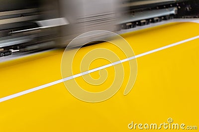 Big professional printer, processing a large scale glossy sheet of yellow paper rolls for color sampling. Stock Photo