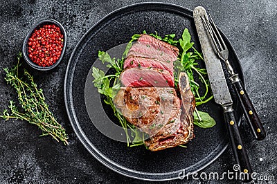 Medium rare sliced grilled striploin beef steak or new york steak. Black background. Top view Stock Photo