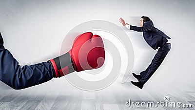 Red boxing glove knocks out little businessman Stock Photo