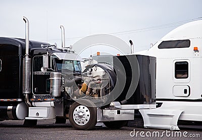 Big rig black semi truck tractor with open hood prepare engine t Stock Photo