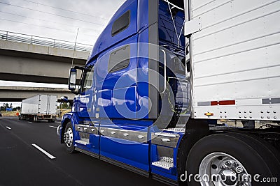 Big rig bright blue long haul semi truck transporting goods in r Stock Photo