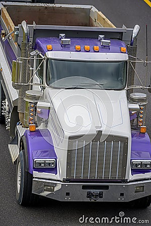 Big rig tip truck with empty dump trailer running on the road to point of work for load Stock Photo