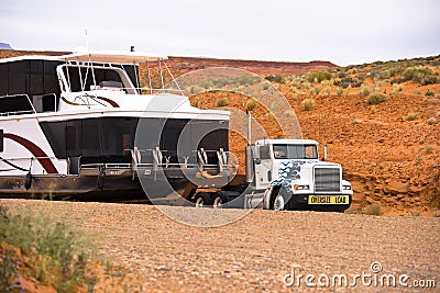 Big rig semi truck transporting huge houseboat on semi trailer in desert of Arizona Lake Powell resort Editorial Stock Photo