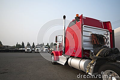 Classic big rig red semi truck tractor park on wide industrial p Stock Photo