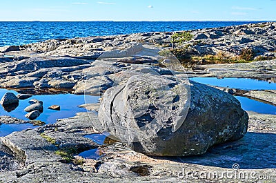 Big rock laying on rocky seashore Stock Photo