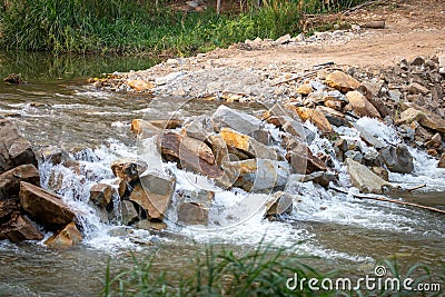 Big Rock Weir, the water overflowing like a waterfall, rural highway Stock Photo
