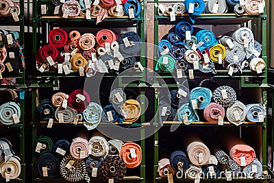 Big rolls of colorful fabric stacked on factory shelves ready for production Stock Photo