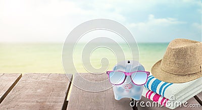 Big sale travel piggy bank with sunglasses relax on the beach. Stock Photo