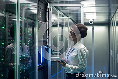 Female technician works on a tablet in a data center Stock Photo