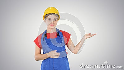 Young builder worker woman presenting showing product with her h Stock Photo