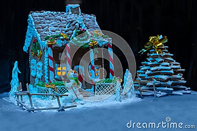 Big snow-covered homemade gingerbread house with lights inside, Stock Photo