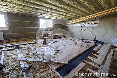Big spacious light empty attic room under construction and renovation. Mansard floor and ceiling insulation with rock wool. Fiber Stock Photo