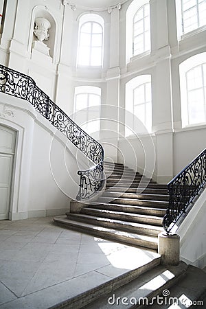 Big staircase with openwork metal curved banister inside Stock Photo