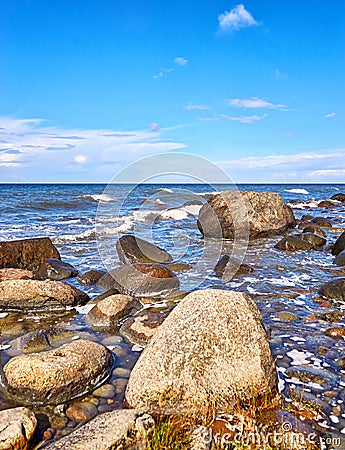 Big stones under blue sky with clouds. Baltic Sea in Mecklenburg-Vorpommern Stock Photo