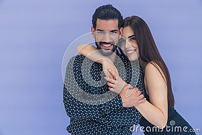 Medium studio copy space shot over violet lavender background of a beautiful heterosexual couple hugging and looking at Stock Photo