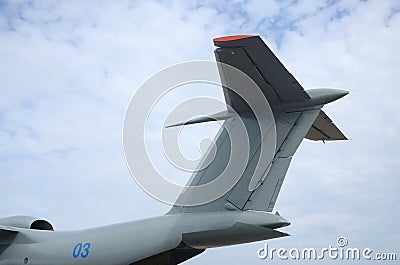 Big tail of armoured military aircraft close up against blue sky Stock Photo