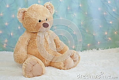 Big teddy bear on furry white blanket Stock Photo