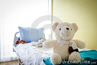 A big teddy bear in a patient`s bed Stock Photo