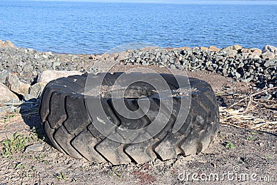 Big Tire on a beach. Pollution and environnement. Stock Photo