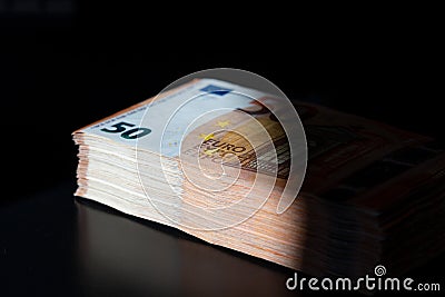 A big wad of money half in the shade Stock Photo