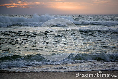 Big waves beat the shore on sunset Stock Photo