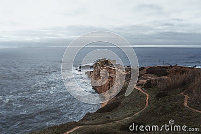 Big Waves of Nazare and Fort of Sao Miguel Arcanjo on a cloudy day - Nazare, Portugal Stock Photo