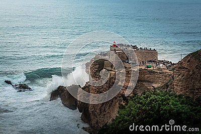 Big Waves of Nazare at Fort of Sao Miguel Arcanjo Lightouse - Nazare, Portugal Stock Photo