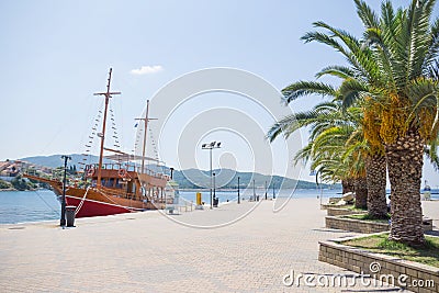 Big white brown wooden sailboat anchored next to the dock in town Stock Photo