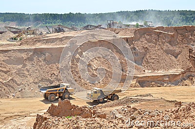 Big yellow dump truck transporting sand in an open-pit mining quarry. Mining quarry for the production of crushed stone, sand and Editorial Stock Photo