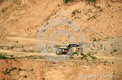 Big yellow dump truck works in an sand open-pit. Editorial Stock Photo