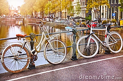 Bike over canal Amsterdam city. Picturesque town landscape in Netherlands with view on river Amstel. Editorial Stock Photo
