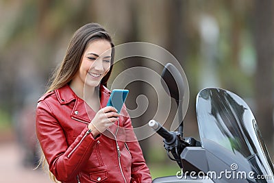 Biker checking phone on her motorbike on the street Stock Photo