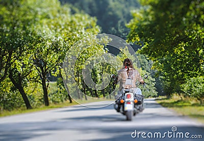 Biker driving on the road in the forest Stock Photo