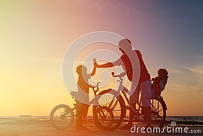 Biker family silhouette, father with two kids on Stock Photo