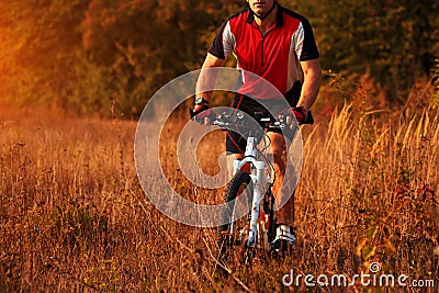 Biker on the forest road riding outdoor Stock Photo