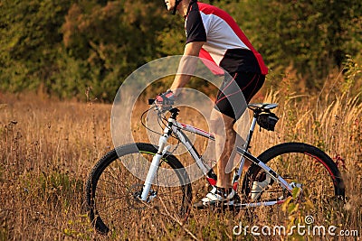 Biker on the forest road riding outdoor Stock Photo