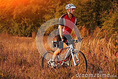 Biker on the forest road riding outdoor Stock Photo