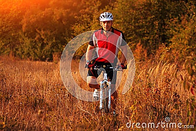 Biker on the forest road riding outdoor Stock Photo