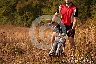 Biker on the forest road riding outdoor Stock Photo