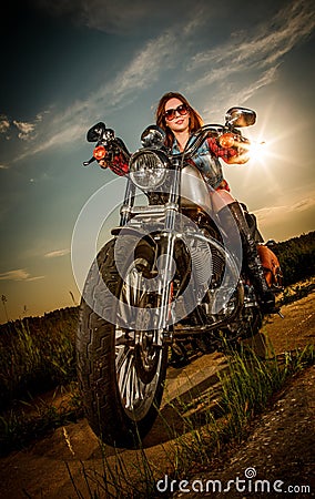 Biker girl sitting on motorcycle Stock Photo