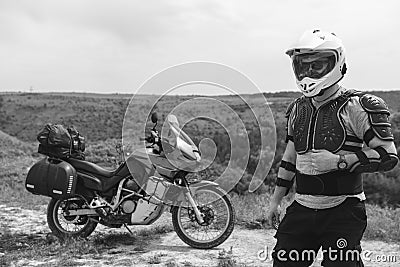 Biker man in a helmet and motorcycle equipment, jacket turtle, body armor. Close. In the background a touristic motorcycle. The Stock Photo
