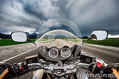 Biker on a motorcycle hurtling down the road in a lightning storm - Forggensee and Schwangau, Germany Bavaria Stock Photo