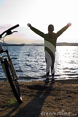 Biker person silhouette. Happy girl near bike Stock Photo