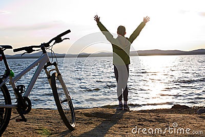 Biker person silhouette. Happy girl near bike Stock Photo