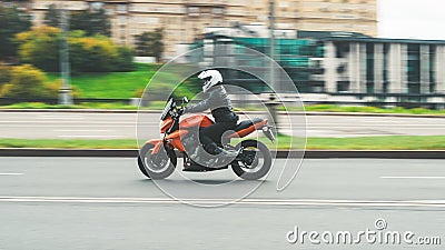 Biker ride Kawasaki motorcycle on the city road with motion blurred background. Motorcyclist in white helmet and black jacket on Editorial Stock Photo